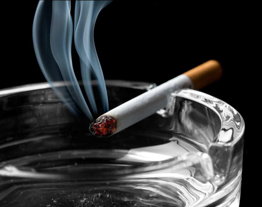 Smoking cigarette in ash tray