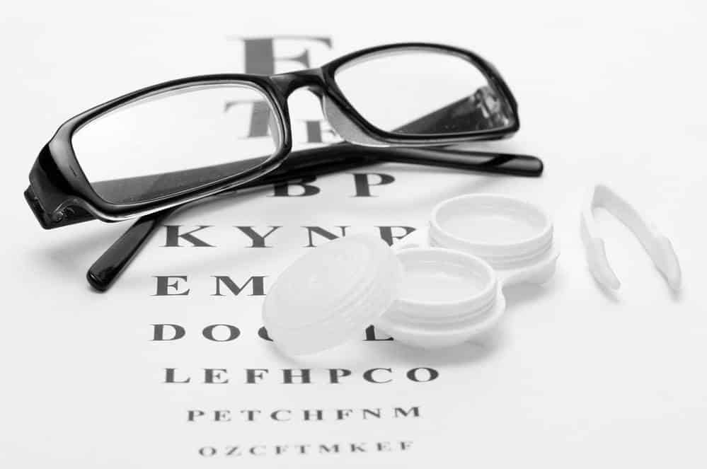 Glasses and contact case resting on eye test