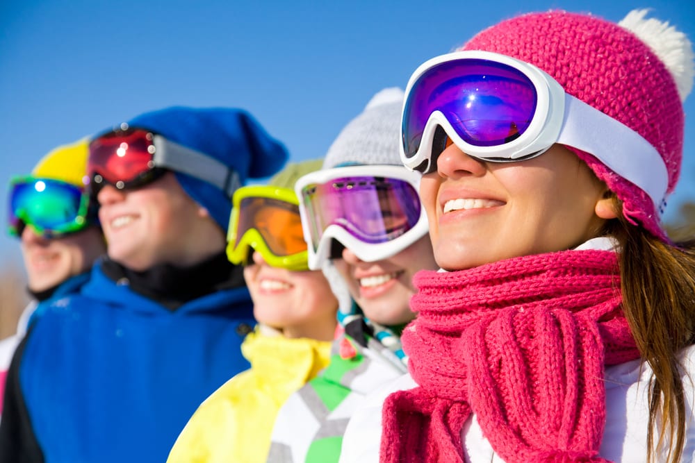Friends wearing colorful ski goggles on ski trip