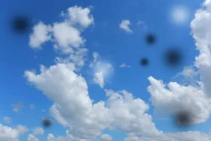 Depiction of eye floaters on photograph of blue sky with clouds