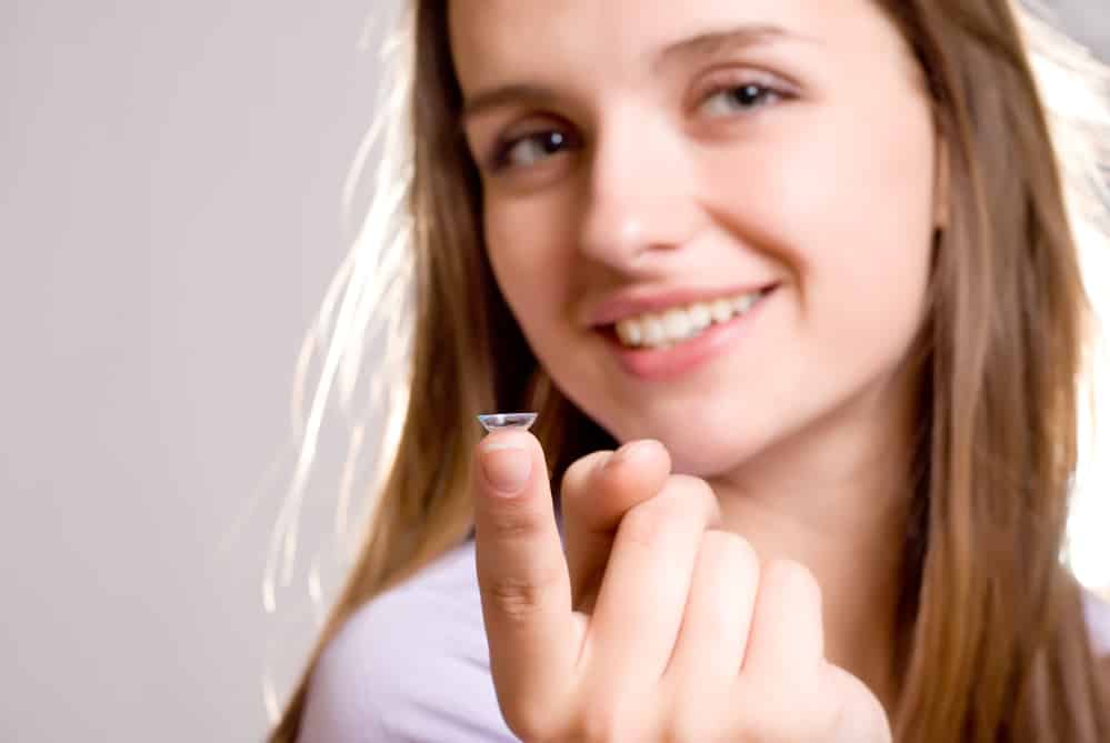 Close-up of contact on the fingertip of smiling young woman