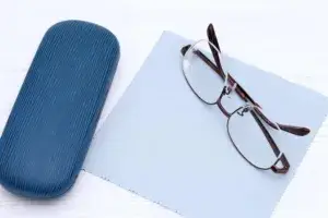 Glasses sitting on top of cloth and beside case