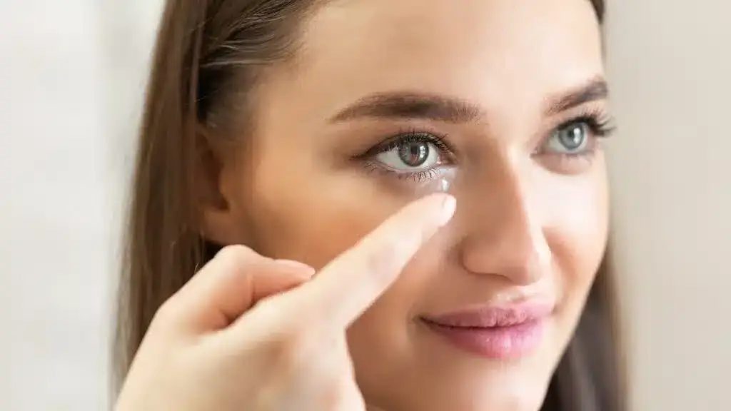 Young woman putting in a contact lens