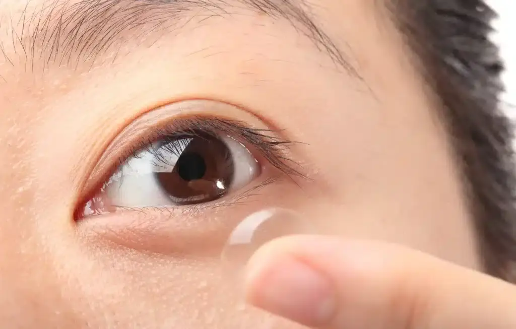 Close-up of woman inserting contact lens