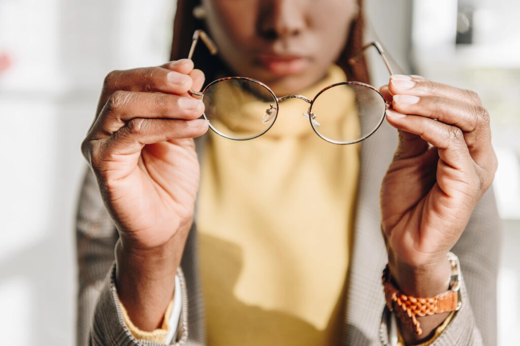 Young woman holding up glasses frames