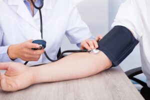 doctor checking patient blood pressure