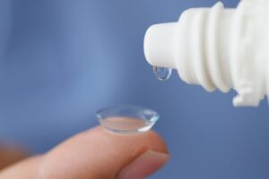 Finger holding contact lens, eye drop bottle