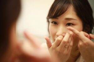 Close-up of woman putting in contact lens
