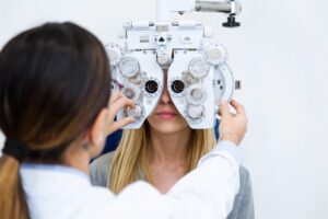 Female optometrist conducting eye exam on young woman