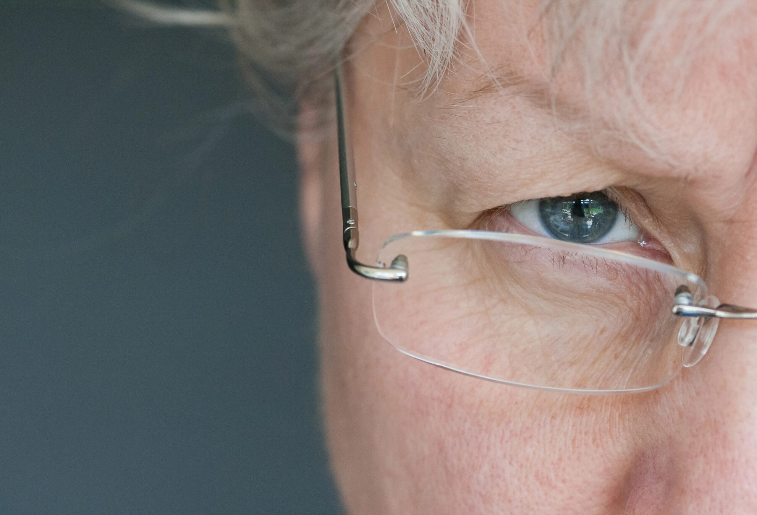 Close-up of senior woman eye wearing rimless glasses