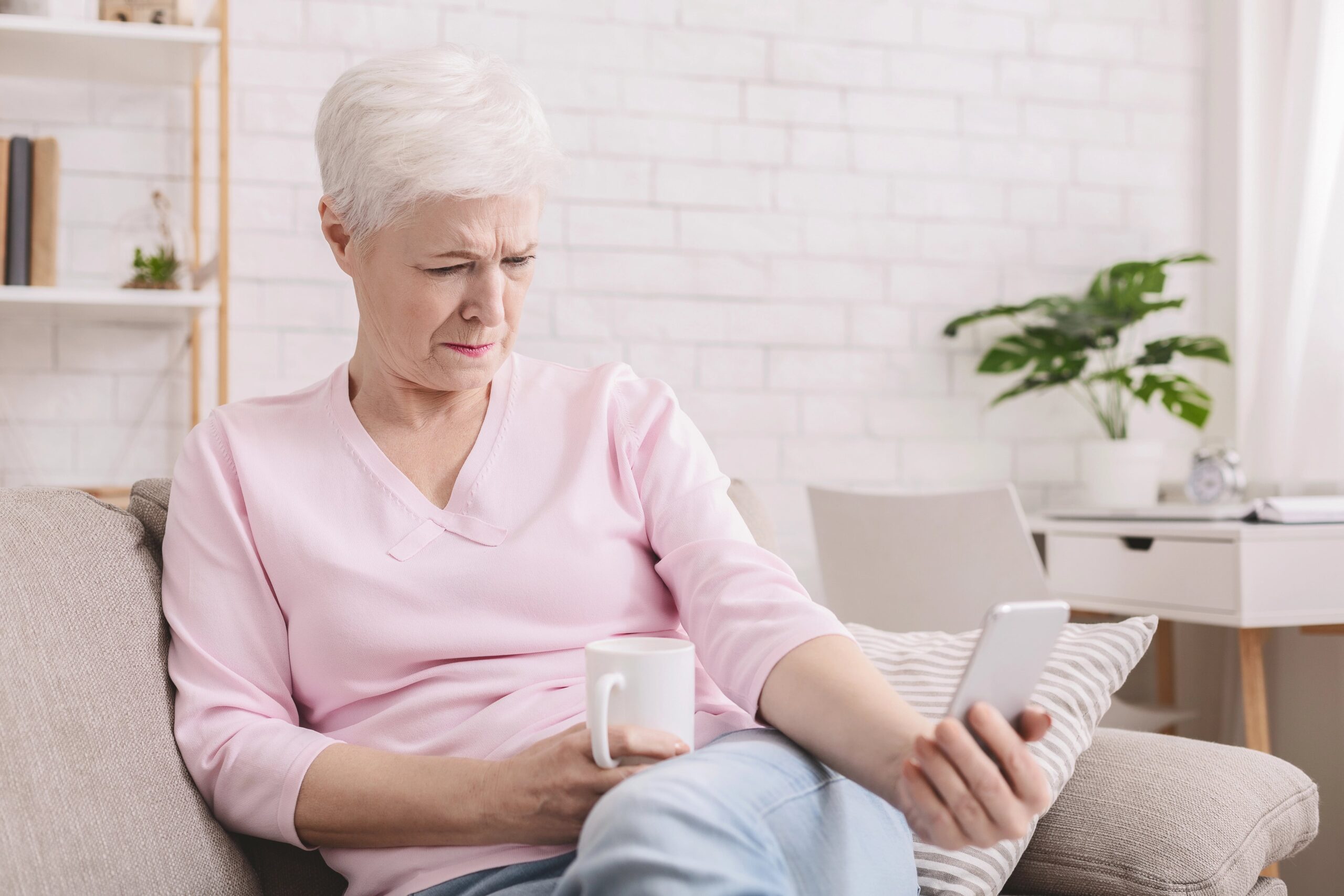 Older woman squinting at phone held far away